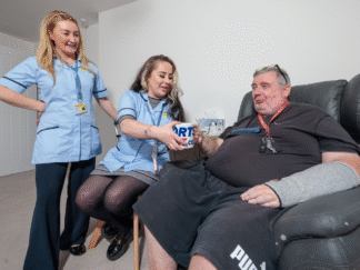 shows two Merseycare Julie Ann workers providing care for a service user