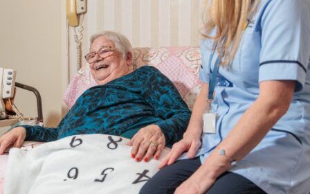 Image of a Care Assistant and an elderly lady in a home setting, with the elderly lady laughing