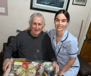A service user and care assistant holding a christmas hamper