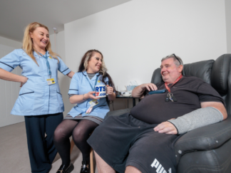 Image shows two carers providing home care for a service user