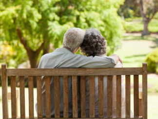 Two elderly people sat on a bench
