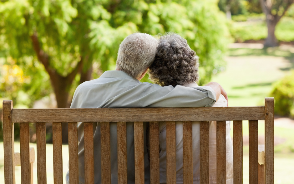 Two elderly people sat on a bench
