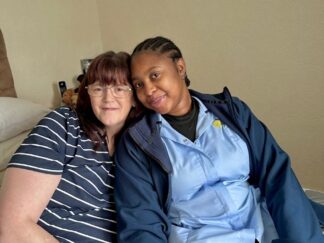 Carer and service user sat close together for blog post on rewarding careers in domiciliary care